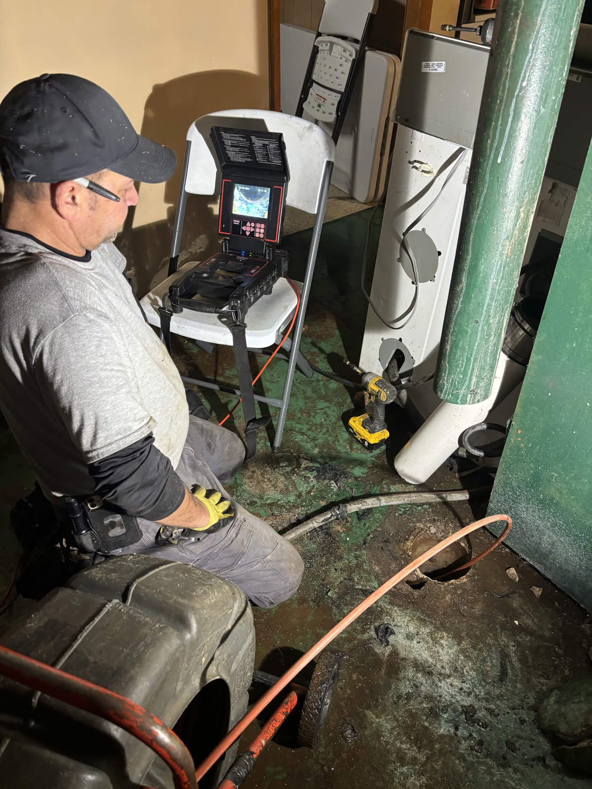 Plumber reviewing sewer camera monitor during a repair job